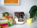 Kawiarka przelewowa Melitta Aromaboy gotowa do zaparzenia porannej kawy. Obok filtry i żółta filiżanka.