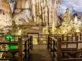 Drewniana kładka prowadzi przez wnętrze jaskini z imponującymi stalaktytami i stalagmitami, przypominającymi krajobraz najdłuższej jaskini w Polsce.