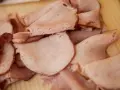 Plastry wędzonej szynki ułożone na desce. Idealne do kanapek, gotowanie szynki wędzonej to świetny pomysł na dodatek.