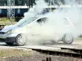 Srebrny samochód z silnikiem diesla wpadł w rozbieganie, wydobywając gęsty biały dym. Kierowca próbuje opanować sytuację.