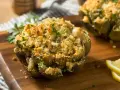 Carciofi ripieni e dorati, cotti alla perfezione nella friggitrice ad aria, guarniti con prezzemolo fresco e spicchi di limone.
