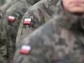 Żołnierze w mundurach moro z polskimi flagami na ramionach, gotowi do służby lub po latach zasłużonej emerytury wojskowej.