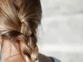 Gładki warkocz z blond włosów, idealny przykład, jak zmniejszyć porowatość włosów.