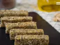 Barritas energéticas caseras de cereales y semillas en una tabla de pizarra.