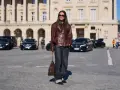 Elegancka kobieta w skórzanej kurtce i jeansach, z brązową torebką na ramieniu. Jej filigranowa figura podkreślona jest przez luźne spodnie i dopasowaną górę.
