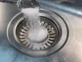 Salt hälls ner i diskhoavloppet. En skopa med salt sprids över silen.