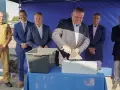 Uroczyste wmurowanie kamienia węgielnego. Mężczyzna w garniturze z kielnią w dłoni symbolicznie rozpoczyna budowę.