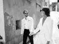 Un couple marié, main dans la main, traverse une ruelle. Ils pensent déjà aux démarches administratives après mariage au service public.
