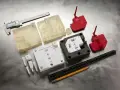 Various 3d printed molds, including clear, white, and red plastic components, are laid out with a caliper, ruler, and pencil on a metallic surface.