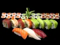Różnorodne sushi: nigiri z łososiem, tuńczykiem i białą rybą, rolki z awokado, krewetką, tuńczykiem i ogórkiem. Idealne na początek nauki, jak jeść sushi.