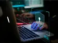Mano sobre teclado de portátil, con un escudo digital de ceros y unos, simbolizando la seguridad informática.