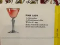 Elegancki kieliszek z różowym drinkiem Pink Lady, obok przepis na jego przygotowanie: grenadyna, gin i białko jaja.