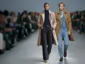 Modelka i model prezentują stylizacje na pokazie. Klasyczne trencze i jeansy to ponadczasowa moda 2026.