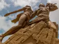 Pomnik Odrodzenia w Senegalu, symbolizujący dumę i przyszłość. Monumentalna rzeźba na tle błękitnego nieba.