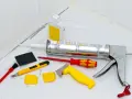 Attrezzi per la rimozione olio di silicone e sigillatura: pistola per silicone, taglierino, spatole, pennello e solvente.