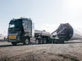 Potężny Volvo FH16 transportuje ogromną łopatę turbiny wiatrowej.