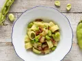 Piatto di pasta con fave fresche e croccante pancetta, un classico saporito.