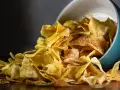Chrupiące chipsy z airfryera wysypują się z turkusowej miseczki. Idealna przekąska!
