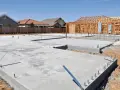 Fundamenty domów w budowie, widać chudy beton i zbrojenia.