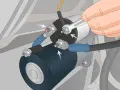 A hand uses a wrench to tighten a bolt on a car's starter solenoid. This could be a fix for bad solenoid symptoms like clicking sounds or a no-start condition.