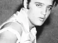 Junger Elvis Presley, mit seinem charakteristischen Blick und jugendlichem Charme, blickt in die Kamera.