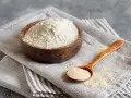 Mąka gryczana w drewnianej misce i na łyżce. Czy mąka gryczana ma gluten? Nie, jest bezglutenowa.