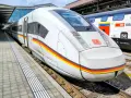 ICE train with German flag colors at a station, ready for a journey between Germany and Switzerland.