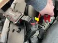 A hand connects red jumper cables from "The Athena" lithium jump starter to a car battery, demonstrating how lithium jump starters work by providing a temporary power boost.