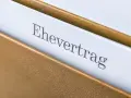 Ein Ehevertrag in einem braunen Ordner. Die Frage, ob man einen Ehevertrag aufheben ohne Notar kann, beschäftigt viele.
