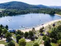 Sommerliche Idylle am Borkener See mit vielen Badegästen, Wasserrutsche und schattigen Plätzen unter Bäumen.