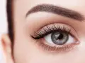 Ojo de mujer con pestañas largas y cejas definidas. Descubre cómo hacer crecer las pestañas para una mirada impactante.