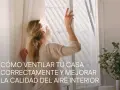 Mujer abriendo ventana para mejorar la **calidad del aire interior**. La luz del sol ilumina su cabello rubio recogido.