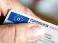 Nahaufnahme eines Führerscheins, der von einer Hand gehalten wird. Die Person könnte versucht sein, trotz Fahrverbot zu fahren.