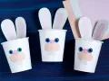 Drei süße Osterhasen-Becher, perfekt für Ostern basteln mit Kleinkindern. Bunte Ohren und lustige Gesichter machen sie zum Hingucker.