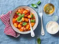 Pyszne gnocchi w sosie pomidorowym, posypane parmezanem. Idealne z kieliszkiem białego wina.