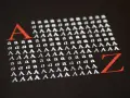 Duża czerwona litera "A" i rzędy białych liter "a" i "A" na czarnym tle, ilustrujące **kerning**. Obok czerwona litera "Z".