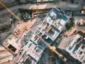 Aerial view of a construction site, showcasing the efficiency of drones in construction by providing an overhead perspective of building progress and material placement.