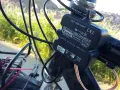 Ładowarka rowerowa Kemo zasilana przez **dynamo**, podłączona do kierownicy, z kablem USB.