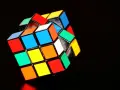 En färgglad rubiks kub 3x3 ligger på en mörk bakgrund.