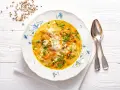 Aromaticzna zupa koperkowa z ryżem, marchewką i kawałkami kurczaka, udekorowana świeżym koperkiem.