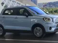Jasnoszary Leapmotor T03 na tle nowoczesnej architektury. Sprawdź, jaka jest leapmotor t03 cena i czy to auto dla Ciebie.