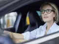 Frau mit Brille fährt Auto. Ohne Brille fahren ohne Brille Strafe.