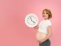 Czekasz na poród? Zegar w rękach ciężarnej sugeruje, jak przyspieszyć poród, choć to tylko symboliczne pytanie.