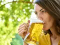 Frau genießt ein kühles Bier im Freien. Vielleicht eine der vielen nordischen Biersorten, die sie entdeckt.