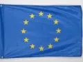 Flaga Unii Europejskiej, symbol jedności i współpracy, z dwunastoma złotymi gwiazdami na niebieskim tle.