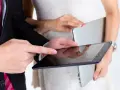 Para młoda planuje zmianę dowodu po ślubie, przeglądając dokumenty na tablecie.