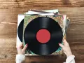 Ręce trzymające stos płyt winylowych. Zastanawiasz się nad wyceną swoich skarbów?