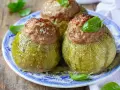 Zucchine tonde ripiene, un piatto gustoso del menù di Benedetta, servite su un piatto blu e bianco con basilico fresco.
