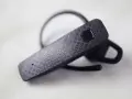 Czarna słuchawka Bluetooth z fakturą kółek, gotowa do połączenia. Dowiedz się, jak sparować słuchawki z telefonem.