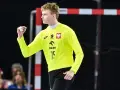 Marcel Jastrzębski, młody bramkarz w żółtej koszulce z orłem, zaciśniętą pięścią świętuje udaną interwencję.